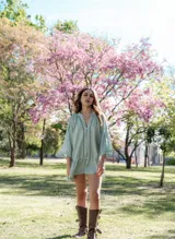 Vestido corto blanco con escote en V, mangas 3/4 con detalle de calado y volados en el ruedo. Cierre frontal con botones.