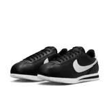 Championes Nike Cortez de cuero negro con detalles en blanco, cordones negros y suela blanca con línea negra.
