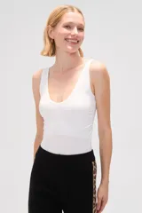 Body blanco sin mangas de poliéster, al cuerpo y cuello redondo.