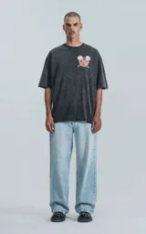 Remera negra con efecto acid wash, corte holgado y estampa frontal con diseño alusivo a Disney.