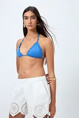 Top de bikini blanco con tirantes finos ajustables al cuello y a la espalda. Presenta volados en el escote y está confeccionado en tejido suave con acabado elástico.