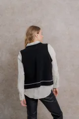 Chaleco tejido color beige, confeccionado en lambswool italiano, con cuello en V y diseño holgado.