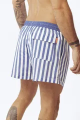 Short de baño con estampado de hojas de palmera en tonos beige, verde y naranja.