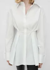 Camisa blanca de algodón con diseño entallado, cuello camisero, mangas largas con detalle metálico y cierre frontal de botones oculto.