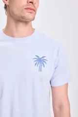 Remera celeste de manga corta con estampa de una palmera en el pecho.