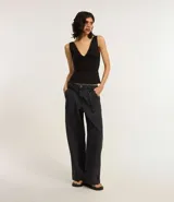 Pantalón skater de jeans color negro, con bolsillos delanteros tipo carpintero, trabillas en la cintura y cierre con botón y cremallera.
