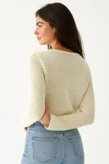Top manga larga color crema, de punto crochet, con escote en V y cierre frontal con lazos.