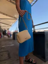 Bandolera pequeña color negro, de material símil cuero, con correa fina y herrajes plateados.