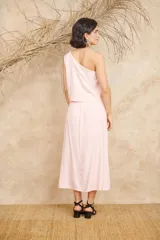 Conjunto negro de dos piezas de lino, compuesto por un top de un hombro con bordados florales y una falda midi con aberturas laterales y bordados florales.