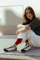 Zapatillas urbanas de cuero color beige con puntera y cordones marrones. Presentan un panel de animal print en el talón y suela de goma color caramelo.