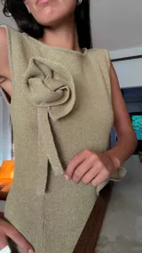 Vestido midi de lurex color ladrillo, con cuello redondo y corte ajustado. Decorado con apliques de rosas de tela color rosa chicle.