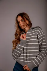 Sweater de punto color beige con rayas horizontales blancas, cuello polo con cierre de cremallera y mangas largas.