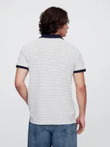 Remera polo de hombre Gap, a rayas horizontales blancas y azul marino. Cuello y mangas en azul marino. Logo de la marca bordado en el pecho.