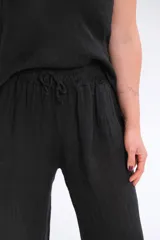 Pantalón palazo negro confeccionado en lino italiano, con cintura elastizada y calce amplio.