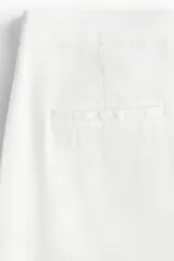 Pantalón sastrero blanco tobillero de tiro alto, con cierre y botón, bolsillos al bies, bolsillos traseros decorativos y piernas amplias con pliegues adelante y atrás. Confeccionado en tejido liviano de lino y viscosa.