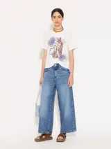Pantalón de jean azul de corte ancho, estilo wide leg cropped, con lavado clásico y detalles de desgaste.