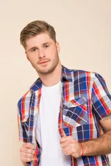 Camisa de manga corta con estampado a cuadros en tonos azul, rojo y blanco. Cierre con botones y tela ligera.