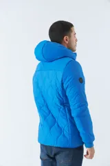 Campera de nylon azul con capucha, cierre frontal con cremallera, bolsillos laterales con cierre y logo de goma en el pecho.