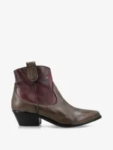 Botín de cuero negro y marrón, de estilo texano, con punta fina, costuras decorativas y taco bajo.