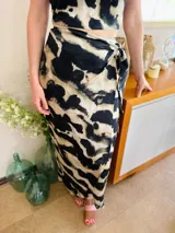 Top corto con estampado abstracto en tonos beige y negro, con escote cruzado y lazos ajustables en la espalda.