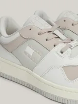 Zapatillas urbanas Tommy Jeans de corte bajo, con exterior de piel en tonos blanco, gris y beige. Presentan suela gruesa de goma, cordones y logo de la marca en el lateral y el talón.