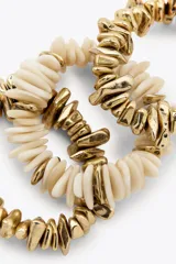 Pack de tres pulseras elásticas con piezas de diferentes formas, tamaños y colores en dorado y blanco.