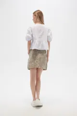 Minifalda de jean color beige con estampado animal print en tonos marrones.