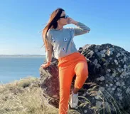 Sweater tejido a mano en lana merino teñida a mano color gris, con diseño de ovejitas blancas bordadas a mano.