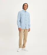 Camisa color beige de algodón texturizado con cuello inglés, botones delanteros, mangas largas y bolsillos delanteros con botón.