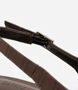 Zapato de tacón marrón con textura de cocodrilo, modelo slingback, con puntera fina, taco bloque mediano y cierre por hebilla.