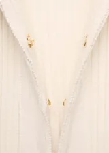 Cárdigan color crema de tejido de punto de canalé con cuello camisero y cierre de gancho frontal.