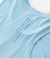 Musculosa deportiva de hombre, color celeste claro, corte regular y cuello redondo. Presenta un logo estampado en el pecho con la palabra "GAU" dentro de una figura ovalada. En el cuello tiene un texto repetido que dice "BETTER EACH DAY".