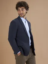 Blazer azul marino de corte clásico, con solapas de muesca, cierre de dos botones, bolsillo de parche en el pecho y bolsillos con solapa en los laterales.