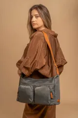 Bandolera de tafeta impermeable, liviana, con dos compartimientos principales, dos bolsillos con cierre y correa regulable con hebilla.