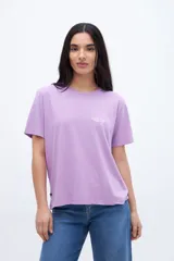 Remera color crema con estampado pequeño en el pecho con la leyenda "UNFRM. Redefining Energy Club".