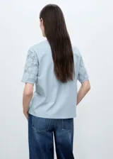 Camiseta blanca de algodón con mangas cortas de crochet y cuello redondo. Diseño recto y calce holgado.