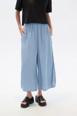 Pantalón capri celeste de denim con cintura elastizada y bolsillos laterales.