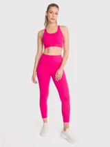 Top deportivo fucsia con soporte medio, almohadillas removibles, tirantes finos con detalle de encaje y espalda con tirante grueso central.