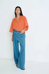 Pantalón culotte de denim azul claro, con cintura elástica fruncida, bolsillos laterales y corte holgado.