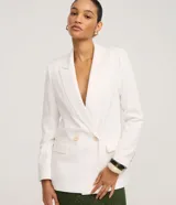 Blazer blanco de corte sastre, cruzado con doble botonadura de dos botones color beige. Presenta solapas de muesca y bolsillos de ojal con tapa en la parte delantera.