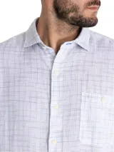 Camisa de manga corta blanca con textura multicolor, confeccionada en lino orgánico y tencel. Tiene bolsillo en el pecho con botón.