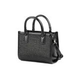 Cartera chica negra con diseño en relieve, confeccionada en rafia y poliuretano. Tiene acceso con cierre, un bolsillo interno con cierre y otro abierto, correa regulable y asa fija.
