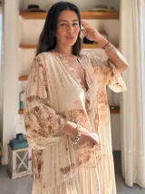 Vestido largo de estilo campesino con estampado de palmeras en tonos blanco y negro, con escote en V y mangas largas abullonadas.
