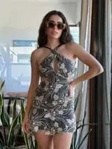 Vestido corto de lentejuelas color verde oliva, con escote en V, breteles finos cruzados en la espalda, cut-outs laterales y volado en el ruedo.