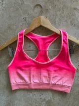 Top deportivo fucsia con breteles anchos y espalda deportiva.