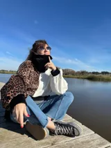 Polerón marrón con estampado animal print de leopardo, puños y cuello negros.