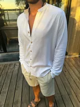 Camisa blanca de lino con cuello mao, manga larga y corte recto.