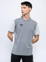 Remera deportiva Umbro de corte clásico, color gris con mangas cortas blancas y logo de la marca en el pecho.