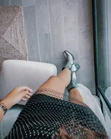 Botín de cuero color marrón con caña media, punta fina y taco geométrico de 10 cm.