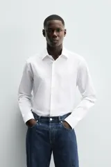 Camisa celeste de corte regular, con cuello italiano, mangas largas con puños abotonados y cierre frontal con botones.